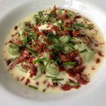 O nhoque de espinafre com ao molho de queijo talégio e crisps de parma